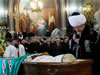 Russia's chief mufti, or Islamic religious leader, Talgan Tadzhuddin, prays near a casket with late Russian Orthodox Patriarch Alexy's body, foreground, placed for public viewing in Moscow's Christ the Savior Cathedral, Sunday, Dec. 7, 2008. Alexy II, who died Friday at age 79, led the church for 18 years, from the last year of the officially atheistic Soviet Union through a massive revival that saw it become the world's largest Orthodox church. Alexy's body was taken Saturday to the huge Christ the Savior Cathedral for three days of public viewing and a Tuesday funeral. (From AP Photo by STR)